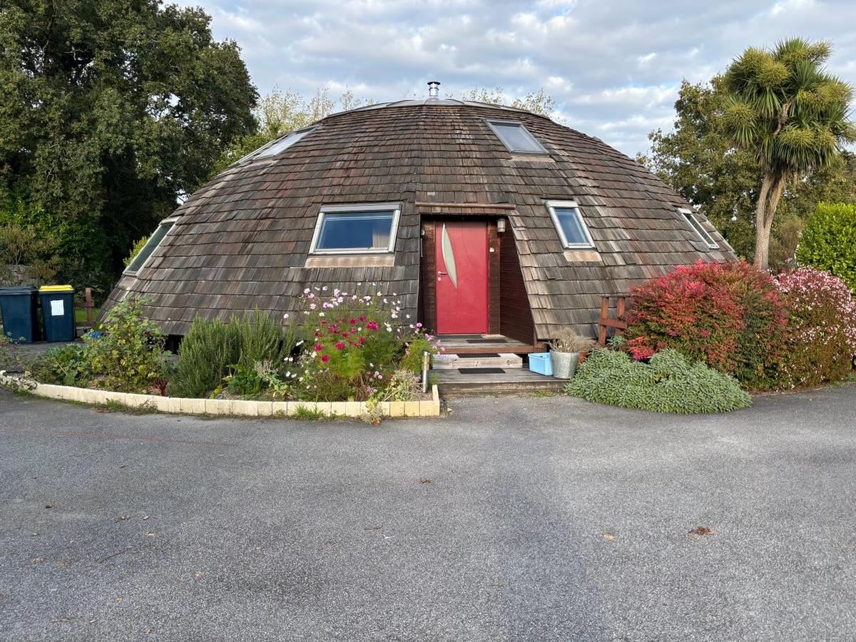 « La maison ronde », le cabinet de Daniel Laurent à Caudan : une maison-dôme en bois à la porte rouge, entourée de fleurs